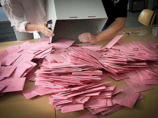 Eine Wahlurne mit Briefwahlunterlagen wird geleert