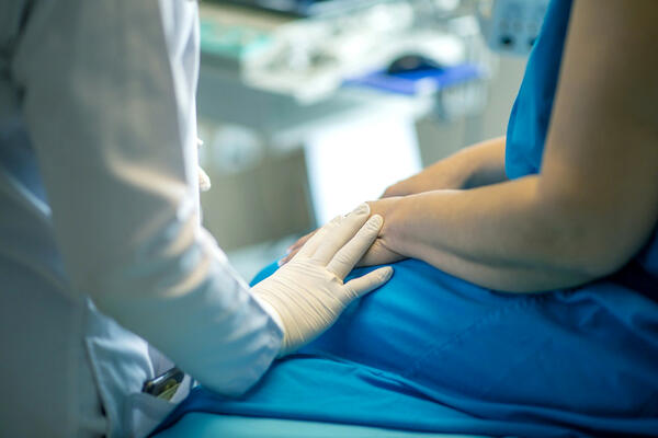 Bild vergrößern: Nahaufnahme medizinisches Personal hält Hand eines Patienten