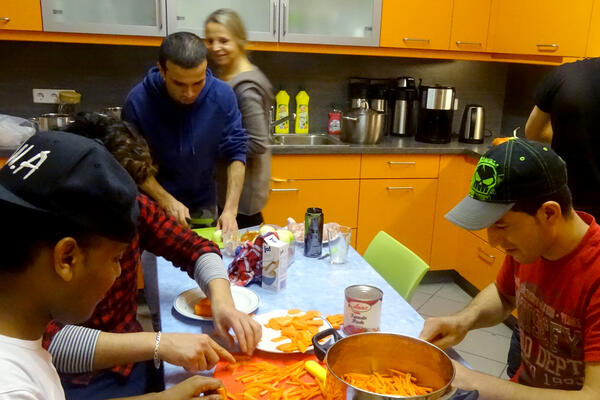 Bild vergrößern: Flüchtlinge kochen gemeinsam