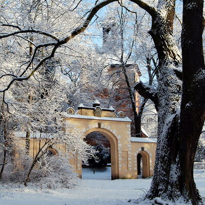 Bild vergrößern: Medusentor und Alte Dorfkirche an einem sonnigen Wintertag