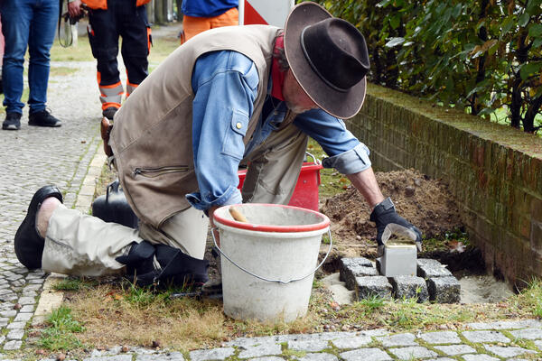 Bild vergrößern: Gunter Demnig verlegt einen Stolperstein im Kiefernweg