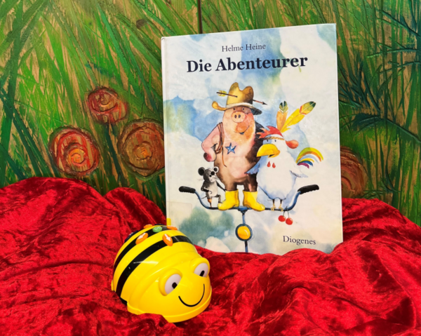 Bild vergr&ouml;&szlig;ern: Buchcover: Maus, Schwein und Hahn stehen auf einem Fahrradlenker. Das Schwein tr&auml;gt einen Hut und gelbe Gummistiefel. Neben dem Buch-Cover sitzt ein Roboter, der wie eine Biene aussieht.