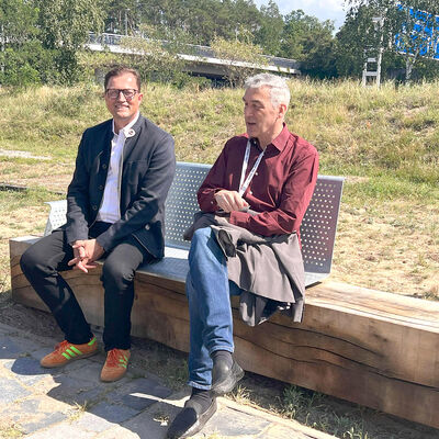 Bild vergr&ouml;&szlig;ern: Zwei M&auml;nner sitzen auf einer der neuen B&auml;nke