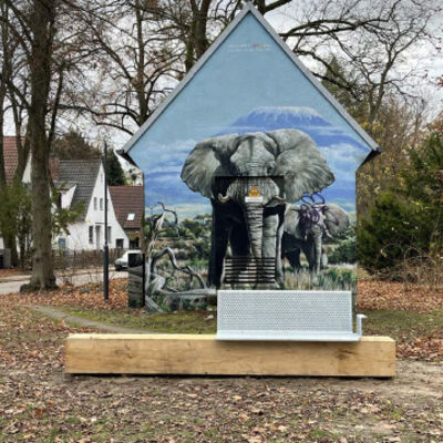 Bild vergr&ouml;&szlig;ern: Sitzbank am Mauerweg vor einer kunstvoll bemalten Fassade