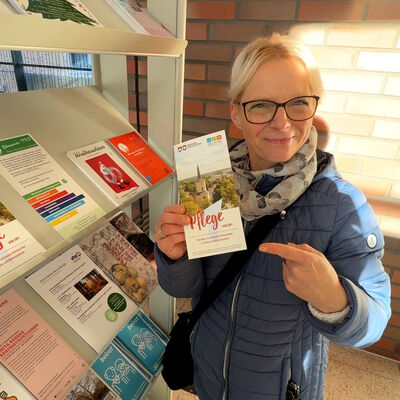 Bild vergr&ouml;&szlig;ern: Bilderserie Pflege vor Ort: Das Foto zeigt eine Beraterin im Rathaus, die auf den Flyer hinweist