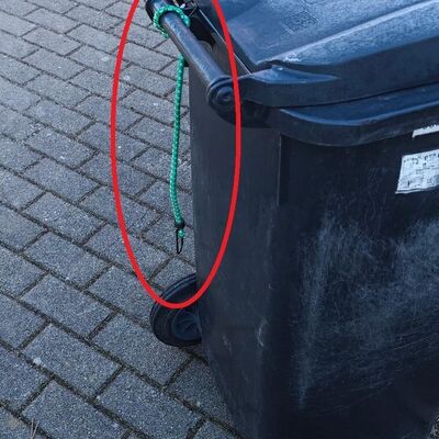 Bild vergr&ouml;&szlig;ern: Das Foto zeigt ein Abfalltonne, die mit einem Gummiband versehen ist.