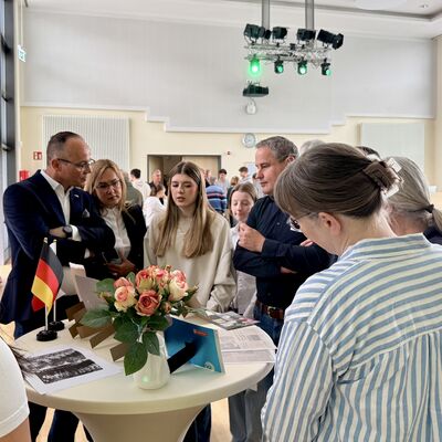 Bild vergr&ouml;&szlig;ern: Bilderserie St&auml;dtepartnerschaftsbesuch 2026: Delegation Schopfheim und Landkreis Swidnica in Kleinmachnow; hier: Gedenkveranstaltung 8. Mai im B&uuml;rgersaal - Sch&uuml;lerinnen des Weinberg-Gymnasiums erkl&auml;ren auf Polnisch das Thema