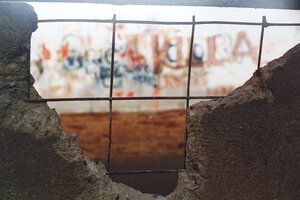 Das Bild zeigt ein St&uuml;ck der Berliner Mauer, aus dem Teile herausgebrochen sind.