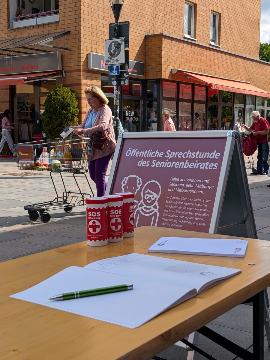 Das Bild zeigt einen Tisch auf dem Rathausmarkt, an dem regelm&auml;&szlig;ig die &ouml;ffentliche Seniorensprechstunde stattfindet.
