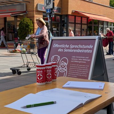 Das Bild zeigt einen Tisch auf dem Rathausmarkt, an dem regelm&auml;&szlig;ig die &ouml;ffentliche Seniorensprechstunde stattfindet.