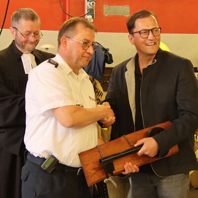 Bild vergr&ouml;&szlig;ern: Das Foto zeigt Pfarrer J&uuml;rgen Duschka, Gemeindewehrf&uuml;hrer Mario Heilmann und B&uuml;rgermeister Bodo Krause am 13. Juni 2026 bei der feierlichen &Uuml;bergabe des neuen Tankl&ouml;schfahrzeugs der Freiwilligen Feuerwehr Kleinmachnow
