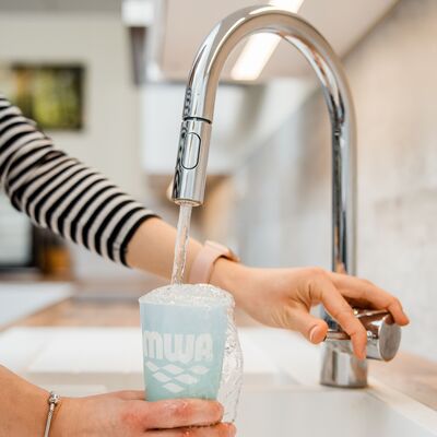 Das Foto zeigt einen laufenden Wasserhahn, unter den eine Frau einen Trinkbecher h&auml;lt