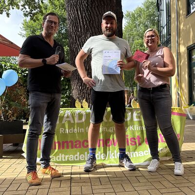 Bild vergr&ouml;&szlig;ern: Das Foto zeigt folgende Situation: Siegerehrung STADTRADELN 2026: B&uuml;rgermeister Bodo Krause (li.) und Fachdienstleiterin Susanne Gasch (re.) gratulieren einem Radler aus dem Team gewog (7042 km) zum tollen Erfolg