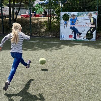 Bild vergr&ouml;&szlig;ern: Das Foto zeigt ein M&auml;dchen, das auf eine Torwand schie&szlig;t