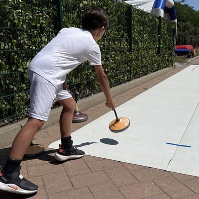 Bild vergr&ouml;&szlig;ern: Das Foto zeigt einen Jungen beim Curling