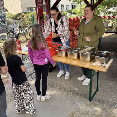 Bild vergr&ouml;&szlig;ern: Das Foto zeigt Kinder, die vor einem Grillstand stehen