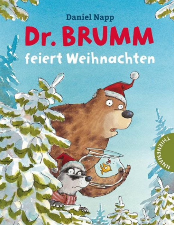 Bild vergr&ouml;&szlig;ern: B&auml;r mit roter M&uuml;tze schaut hinter eingeschneitem Baum hervor