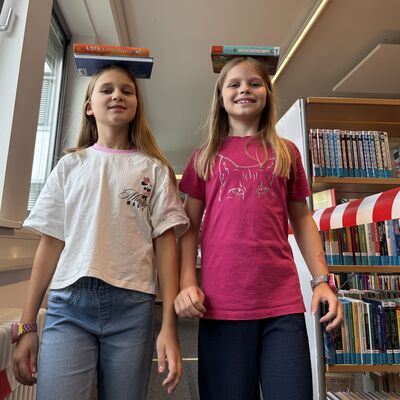 Bild vergr&ouml;&szlig;ern: Das Foto zeigt zwei M&auml;dchen beim Balancieren von B&uuml;chern auf dem Kopf beim Sportlichern Aktionstag rund ums Rathaus am 5. September 2026