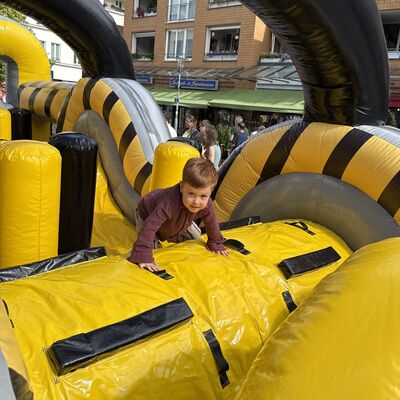 Bild vergr&ouml;&szlig;ern: Das Foto zeigt einen kleinen Jungen beim Krabbeln durch den Ninja-Parcours beim Sportlichern Aktionstag rund ums Rathaus am 5. September 2026