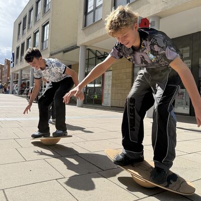 Bild vergr&ouml;&szlig;ern: Das Foto zeigt zwei Jugendliche bei der Surf-Station beim Sportlichern Aktionstag rund ums Rathaus am 5. September 2026