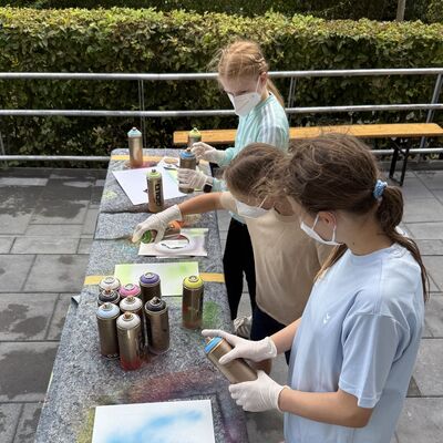 Bild vergr&ouml;&szlig;ern: Das Foto zeigt drei M&auml;dchen beim Sportlichern Aktionstag rund ums Rathaus am 5. September 2026 beim Streetart-Workshop im Jugendhaus Carat
