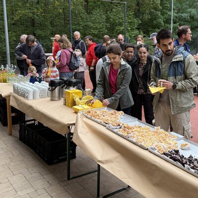 Bild vergr&ouml;&szlig;ern: Das Foto zeigt Menschen, die bei Kuchen, Kaffee und Limo den WCD 2026 nach getaner Arbeit gem&uuml;tlich auf dem Schulhof der Grundschule Auf dem Seeberg und des Hortes Hochwald ausklingen lassen.