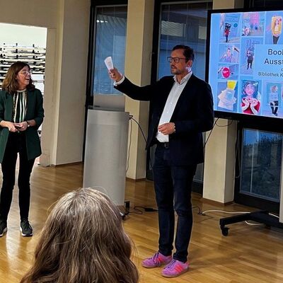 Bild vergr&ouml;&szlig;ern: Das Foto zeigt B&uuml;rgermeister Bodo Krause und Bibliotheks-Leiterin Sandra D&uuml;llmann bei der Er&ouml;ffnung der Bookface-Ausstellung im Rathaus Kleinmachnow