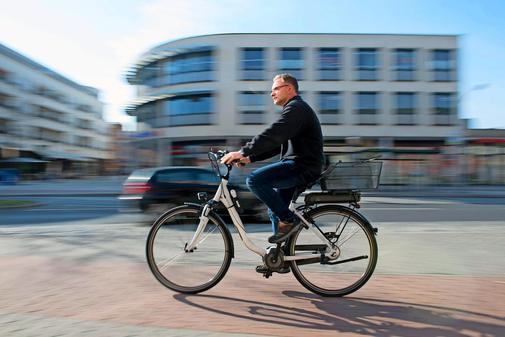 Bild vergrößern: Mann fährt auf E-Bike