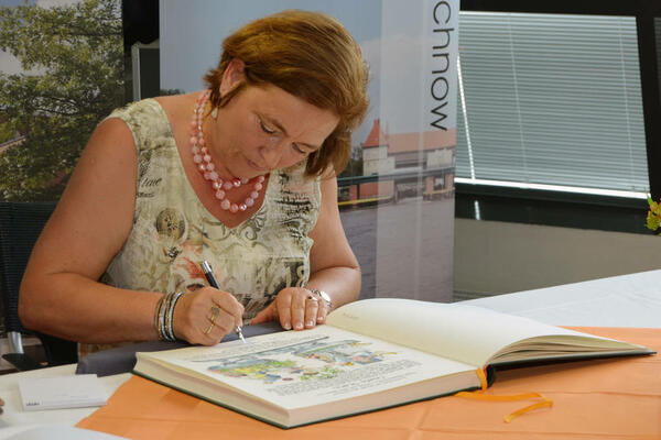 Bild vergr&ouml;&szlig;ern: Gisela Stahn setzt ihre Unterschrift unter die f&uuml;r sie gestaltete Seite im Goldenen Buch Kleinmachnows