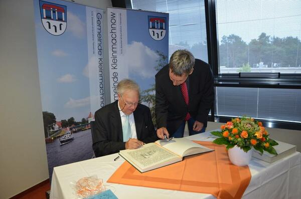 Bild vergr&ouml;&szlig;ern: Professor Dr. Hubert Faensen setzt seine Unterschrift auf die von Rainer Ehrt gestaltete Seite des Goldenen Buchs